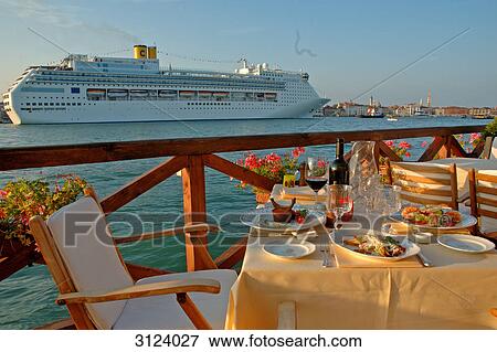 Stock Photo - Chairs and tables on the Hotel Cipriani terrace, cruise ship passing by, Giudecca, Venice, Italy . Fotosearch