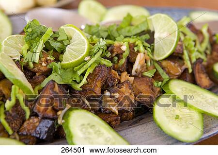 Stock Image - Close-up of slices of cucumber and lemon on plate . Fotosearch
