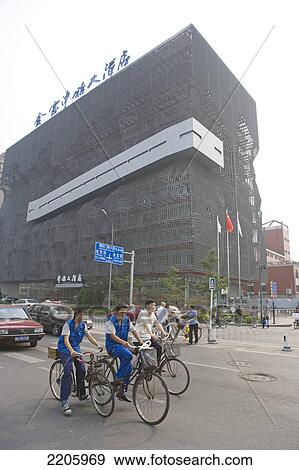 Cyclists on city road in front of building, China View Large Photo Image Stock Photo - Cyclists on city road in front of building, China . Fotosearch