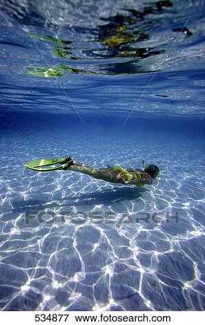 Female scuba diver swimming underwater View Large Photo Image Stock Photo - Female scuba diver swimming underwater . Fotosearch