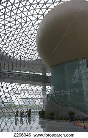 Stock Photograph - Group of people walking inside modern building . Fotosearch