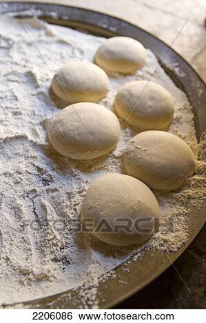 Stock Photograph - High angle view of dough balls and flour . Fotosearch