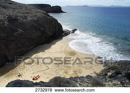 High angle view of person sunbathing on beach, Lanzarote, Canary Islands, Spain View Large Photo Image Stock Photo - High angle view of person sunbathing on beach, Lanzarote, Canary Islands, Spain . Fotosearch