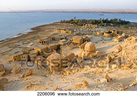 Stock Photograph - High angle view of village at bank of salt lake, Siwa Oasis, Libyan Desert, Egypt . Fotosearch