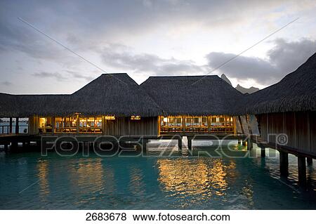 Huts lit up during dusk at resort on beach View Large Photo Image Stock Photo - Huts lit up during dusk at resort on beach . Fotosearch