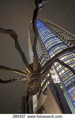 Stock Photo - Low angle view of sculpture in front of tower, Mori Tower, Tokyo Prefecture, Japan . Fotosearch
