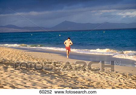 Man running on beach, Fuerteventura, Canary Islands, Spain View Large Photo Image Stock Image - Man running on beach, Fuerteventura, Canary Islands, Spain . Fotosearch