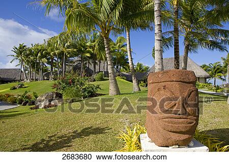 Stock Image - Megalith stone and palm trees in resort, Saint-Regis Resort, Bora Bora, Society Island, French Polynesia . Fotosearch