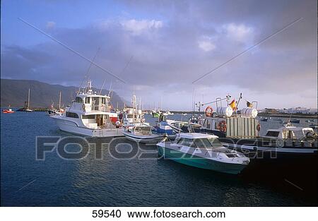 Motor boats in sea waters under cloudy sky, La Graciosa, Canary Islands, Spain View Large Photo Image Stock Image - Motor boats in sea waters under cloudy sky, La Graciosa, Canary Islands, Spain . Fotosearch