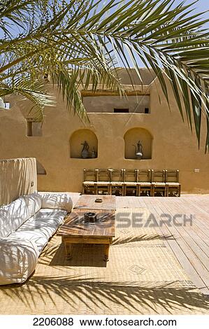 Palm tree with couch in hotel, Hotel Kinooz shali, Siwa Oasis, Libyan Desert, Egypt View Large Photo Image Stock Photo - Palm tree with couch in hotel, Hotel Kinooz shali, Siwa Oasis, Libyan Desert, Egypt . Fotosearch