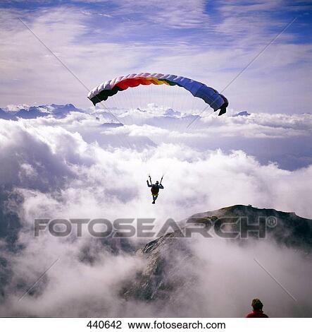 Paraglider paragliding over mountain range, Allgaeu, Bavaria, Germany View Large Photo Image Stock Image - Paraglider paragliding over mountain range, Allgaeu, Bavaria, Germany . Fotosearch