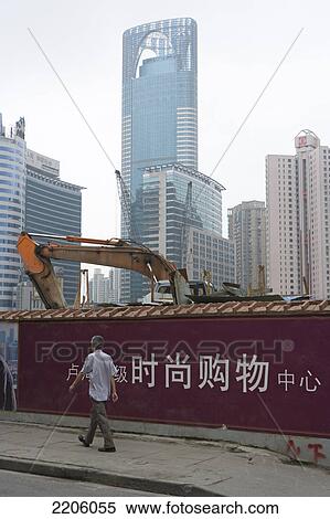 Person walking against bulldozer and buildings in city View Large Photo Image Stock Photography - Person walking against bulldozer and buildings in city . Fotosearch
