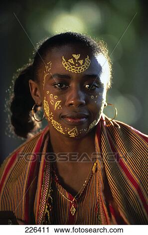 Stock Image - Portrait of native African girl with face decorated with designs . Fotosearch