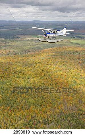 Stock Photo - Propeller plane flying over landscape, Canada, Quebec . Fotosearch
