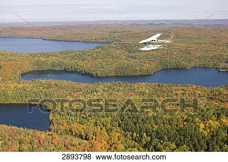 propeller plane flying over the Sacacomie lake at Quebec, Canada View Large Photo Image Stock Photo - propeller plane flying over the Sacacomie lake at Quebec, Canada . Fotosearch