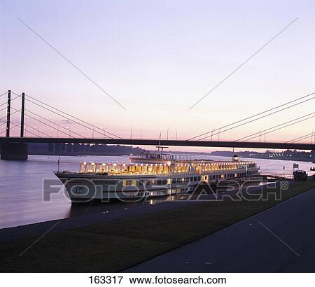 Ship at harbor lit up at dusk, Duesseldorf, North Rhine Westphalia, Germany View Large Photo Image Stock Photo - Ship at harbor lit up at dusk, Duesseldorf, North Rhine Westphalia, Germany . Fotosearch