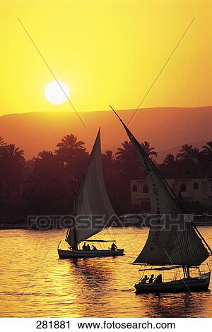 Silhouette of two sailboats in river at dusk, Luxor, Egypt View Large Photo Image Stock Image - Silhouette of two sailboats in river at dusk, Luxor, Egypt . Fotosearch