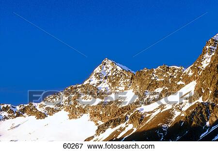 Snowcovered mountains against blue sky, Timmelsjoch, Austria View Large Photo Image Stock Photo - Snowcovered mountains against blue sky, Timmelsjoch, Austria . Fotosearch
