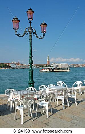 Tables and chairs on a seaside promenade, Giudecca, Venice, Italy View Large Photo Image Stock Photo - Tables and chairs on a seaside promenade, Giudecca, Venice, Italy . Fotosearch