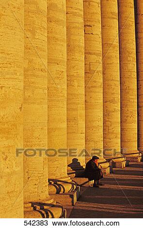 Stock Image - Tourist sitting near colonnade, Berninis Colonnade, St. Peters Square, Vatican City, Rome, Italy . Fotosearch