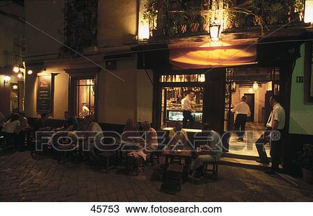 Tourists at restaurant during night, Barrio de Santa Cruz, Seville, Andalusia, Spain View Large Photo Image Stock Image - Tourists at restaurant during night, Barrio de Santa Cruz, Seville, Andalusia, Spain . Fotosearch