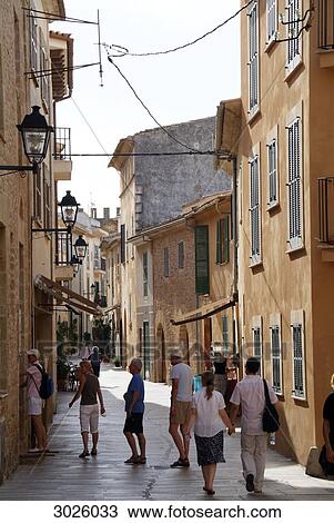 Tourists in an alley in the old town of Alcudia, Majorca, Spain View Large Photo Image Stock Image - Tourists in an alley in the old town of Alcudia, Majorca, Spain . Fotosearch