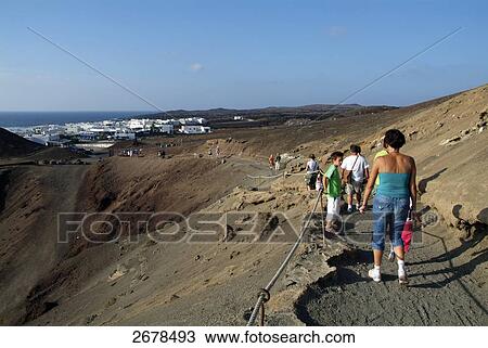 Tourists on volcanic landscape, El Golfo, Lanzarote, Canary Islands, Spain View Large Photo Image Stock Image - Tourists on volcanic landscape, El Golfo, Lanzarote, Canary Islands, Spain . Fotosearch