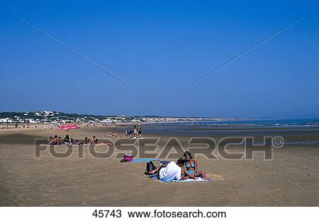 Stock Image - Tourists relaxing on beach, Playa de Mazagon, Costa de la Luz, Andalusia, Spain . Fotosearch