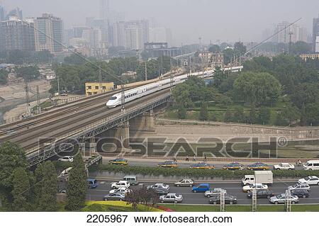 Stock Photo - Train crossing bridge over highway, China . Fotosearch