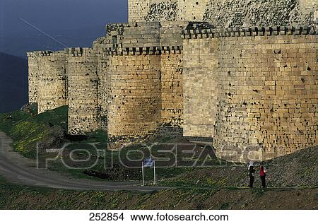 Picture - Two people standing near information board in front of castle . Fotosearch