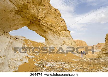 Two people standing near rock formation, Egypt View Large Photo Image Picture - Two people standing near rock formation, Egypt . Fotosearch