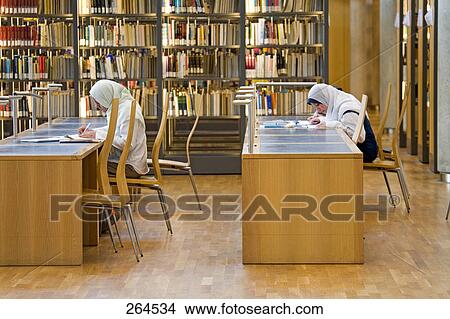 Two women sitting in library View Large Photo Image Picture - Two women sitting in library . Fotosearch