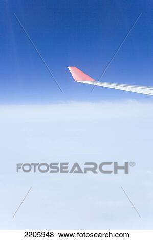View of plane wing in flight against sky View Large Photo Image Stock Photo - View of plane wing in flight against sky . Fotosearch