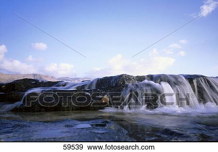 Water flowing through rocks under blue sky, La Gomera, Canary Islands, Spain View Large Photo Image Stock Photo - Water flowing through rocks under blue sky, La Gomera, Canary Islands, Spain . Fotosearch