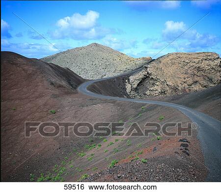 Stock Photograph - Winding road running through mountains, Timanfaya National Park, Lanzarote, Spain . Fotosearch