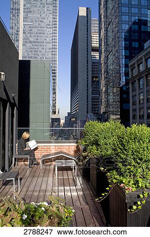 Woman sitting in balcony and reading book, Times Square, 42nd Street, Manhattan, USA View Large Photo Image Stock Photo - Woman sitting in balcony and reading book, Times Square, 42nd Street, Manhattan, USA . Fotosearch