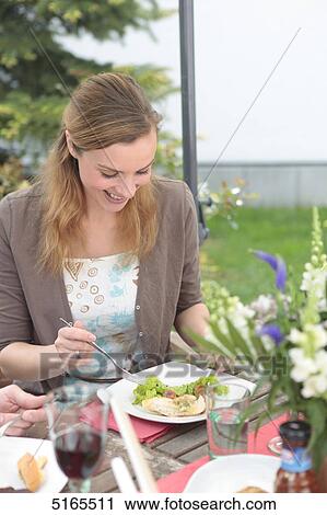 Young woman eating at table View Large Photo Image Stock Image - Young woman eating at table . Fotosearch