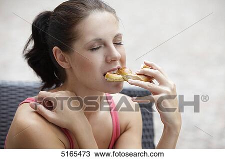 Young woman eating pretzel View Large Photo Image Stock Image - Young woman eating pretzel . Fotosearch