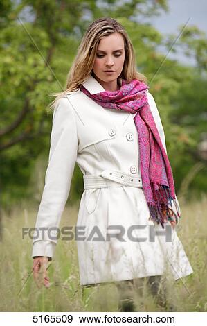 Young woman in white trench coat View Large Photo Image Stock Photo - Young woman in white trench coat . Fotosearch