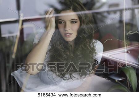 Young woman looking out of the window View Large Photo Image Picture - Young woman looking out of the window . Fotosearch