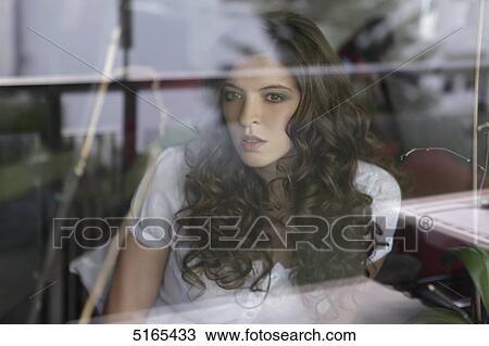 Young woman looking out of the window View Large Photo Image Stock Image - Young woman looking out of the window . Fotosearch