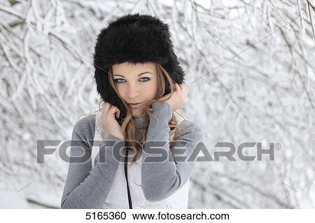 Young woman with cap in snow View Large Photo Image Stock Image - Young woman with cap in snow . Fotosearch