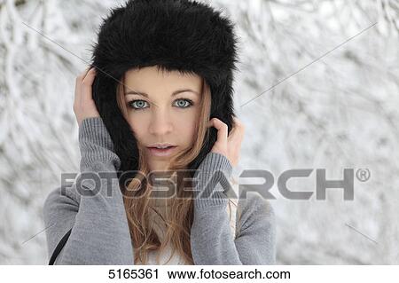 Stock Image - Young woman with cap in snow . Fotosearch