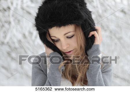Young woman with cap in snow View Large Photo Image Stock Image - Young woman with cap in snow . Fotosearch