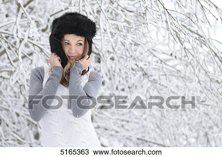 Stock Image - Young woman with cap in snow . Fotosearch
