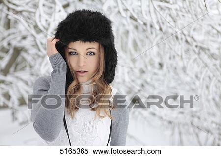 Stock Photography - Young woman with cap in snow . Fotosearch
