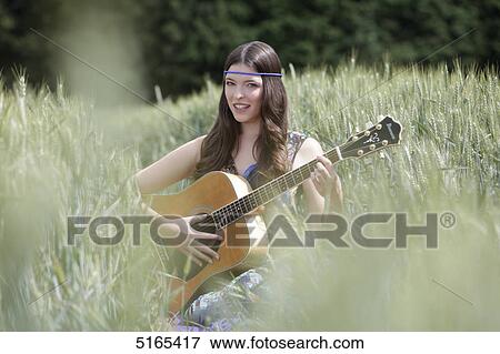 Young woman with guitar in corn field View Large Photo Image Stock Photo - Young woman with guitar in corn field . Fotosearch