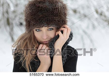 Young woman with scarf and cap in snow View Large Photo Image Stock Image - Young woman with scarf and cap in snow . Fotosearch