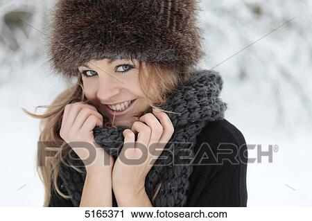 Young woman with scarf and cap in snow View Large Photo Image Stock Image - Young woman with scarf and cap in snow . Fotosearch
