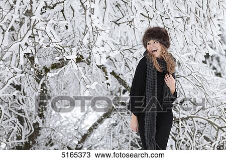Young woman with scarf and cap in snow View Large Photo Image Stock Image - Young woman with scarf and cap in snow . Fotosearch